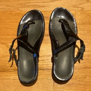 Ladies dansko slip on black patent leather sandals.